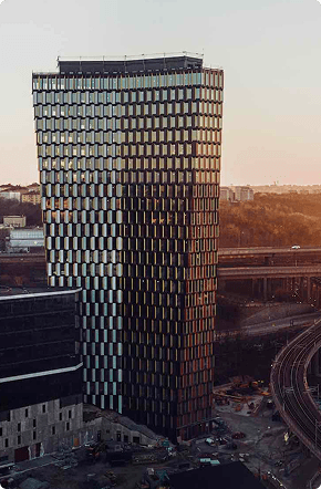 Moderni toimistotorni moottoritieliittymän lähellä auringonlaskussa